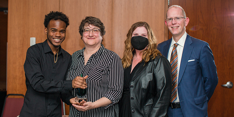 four people holding award