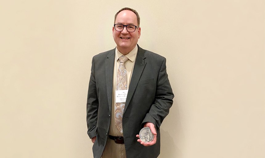 Gary Gibbs holds a medal