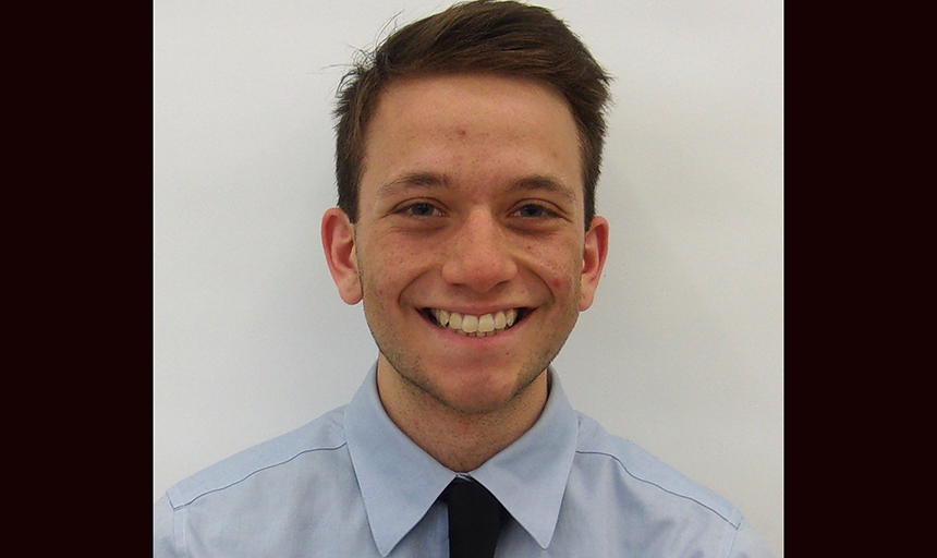 Student with short brown hair wearing blue shirt and tie