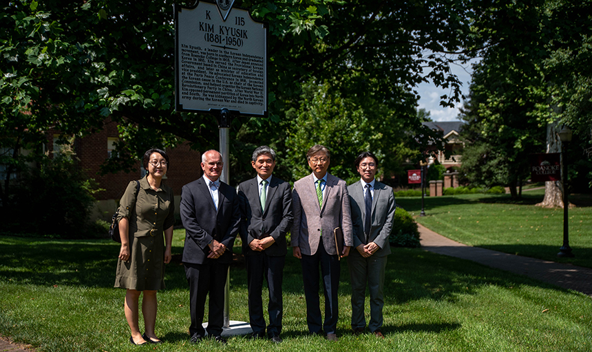 Five people stand in front of Kim Kyusik historic marker. 