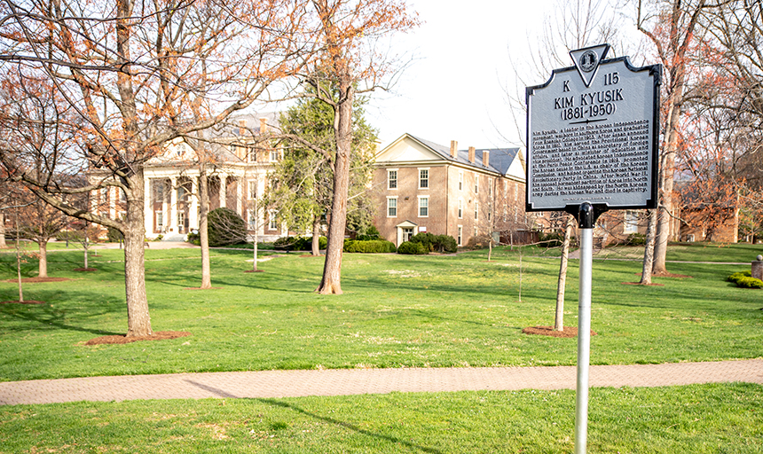 Kim Kyusik historic marker with grass lawn and historic brick building in background