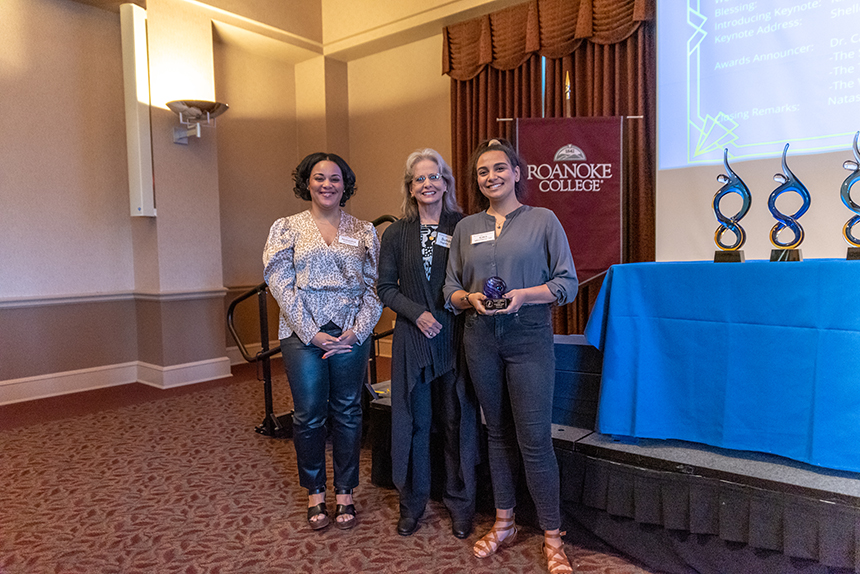 three women pose with award