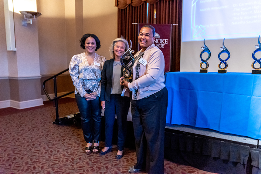 three women pose with award