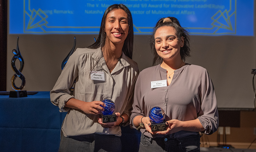 Two female students pose with awards