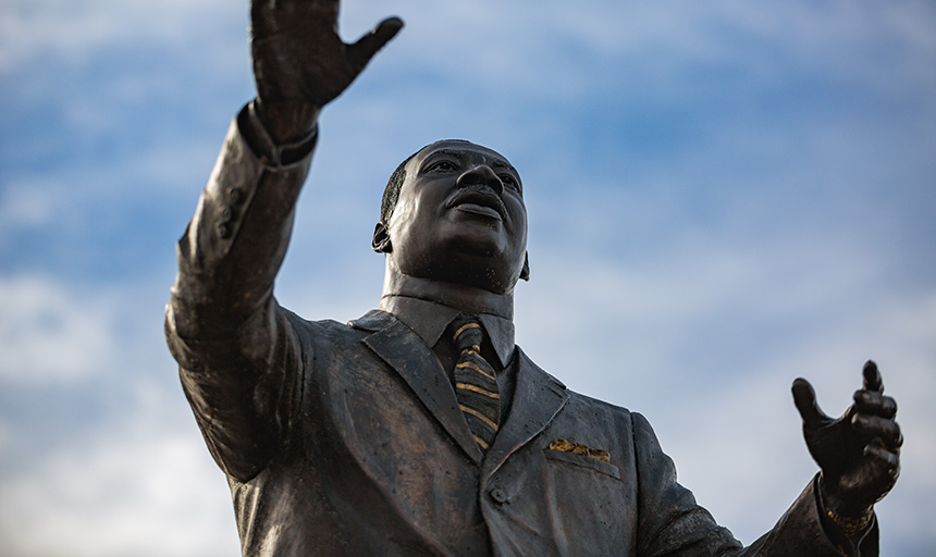 A bronze statue of Martin Luther King Jr. with arms outstretched
