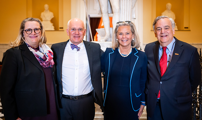 Four people stand in the Virginia State Capitol