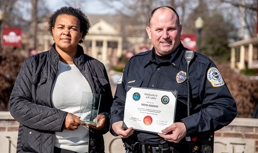 April McCadden holds award standing beside Kevin Assenat holding a certificate