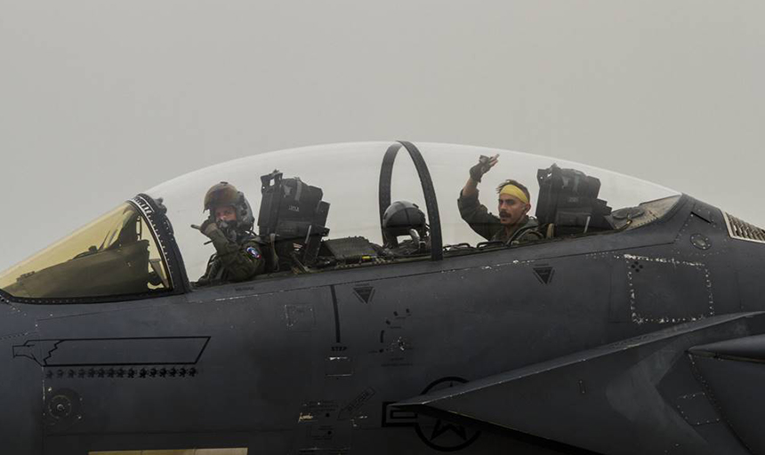 Men wave from cockpit of fighter jet