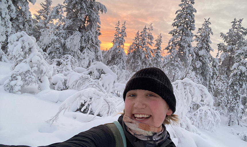 Young woman with snow-covered trees and sunrise lighting