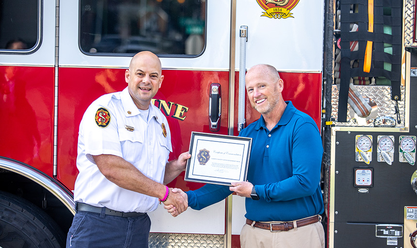 Salem Fire-EMS Chief John Prillaman (left) presents a commendation praising Roanoke College Campus Safety Officer Robert Ross.