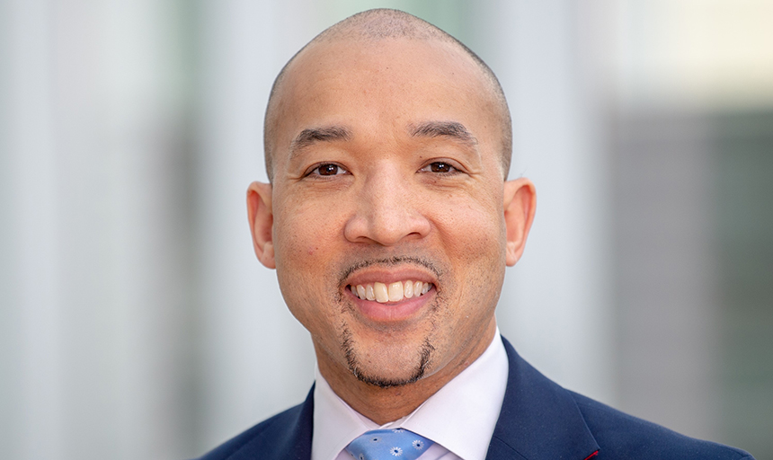 Paris Butler headshot, smiling in a suit and tie