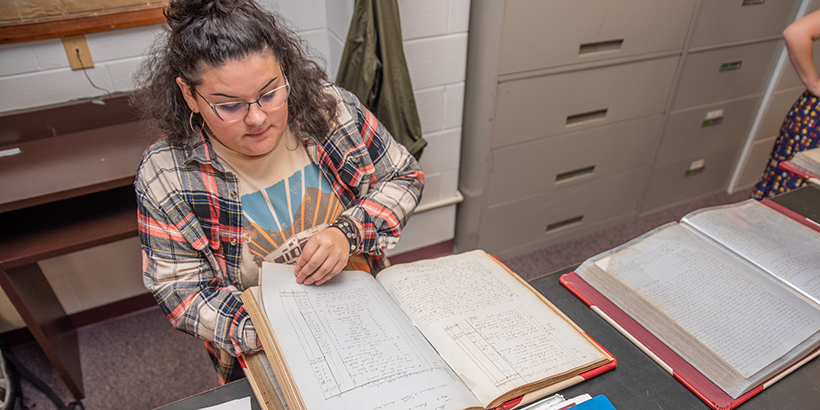 A student goes through handwritten record book