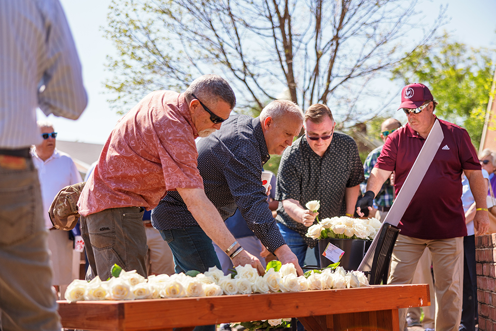 Men pick white roses on table outdoors