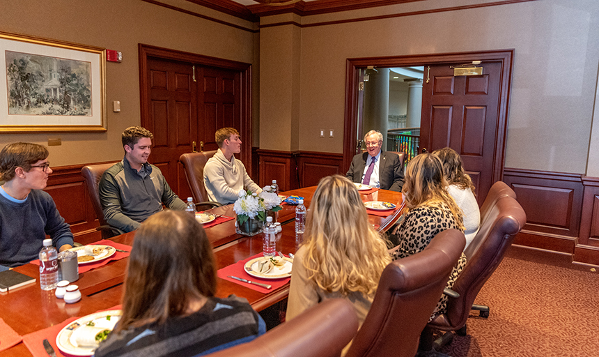 Forbes eats lunch and discusses inflation with a group of Roanoke College students.