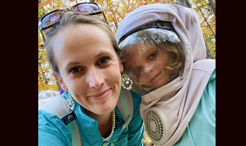 Johanna Sweet and her daughter Emma wearing a full protective hat with face shield