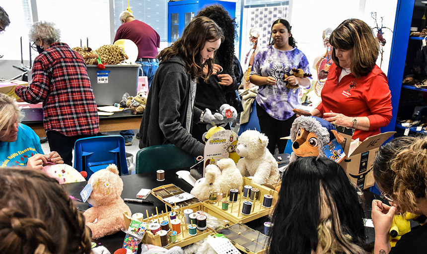 Students and community volunteers working on modifying toys