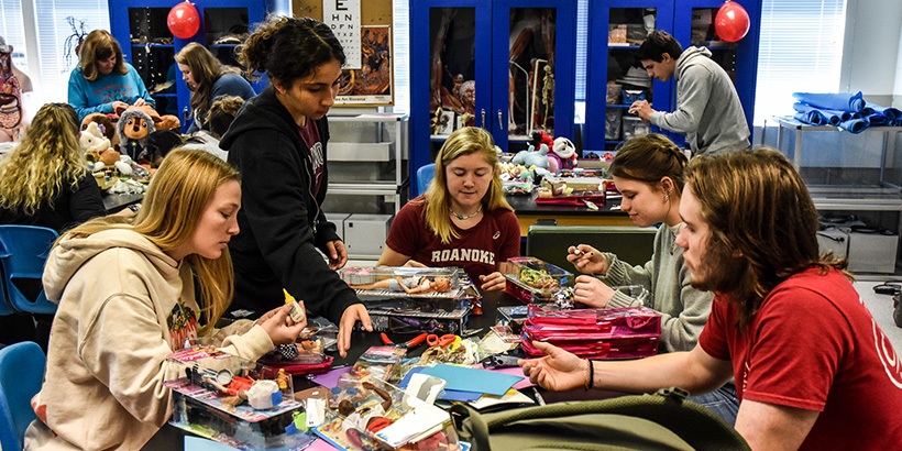 Students gather around a table on campus to modify toys for Toy Like Me at Roanoke College.