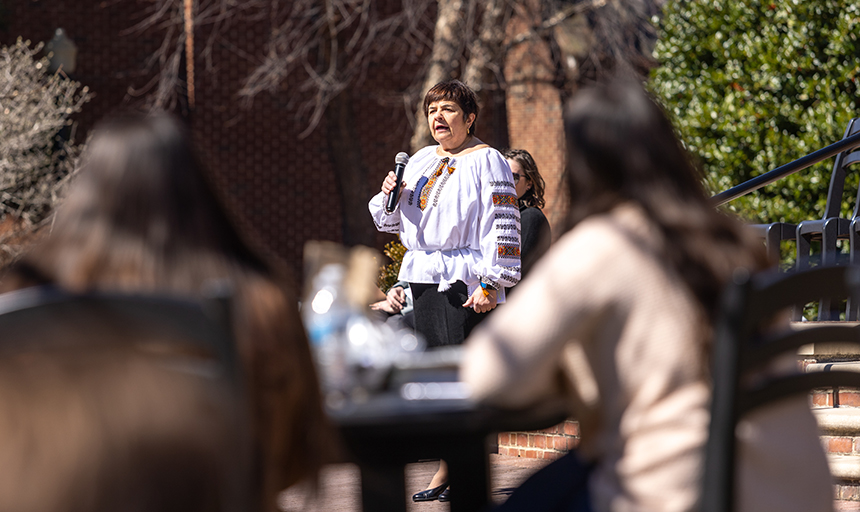 Professor in embroidered Ukrainian garb speaking to students