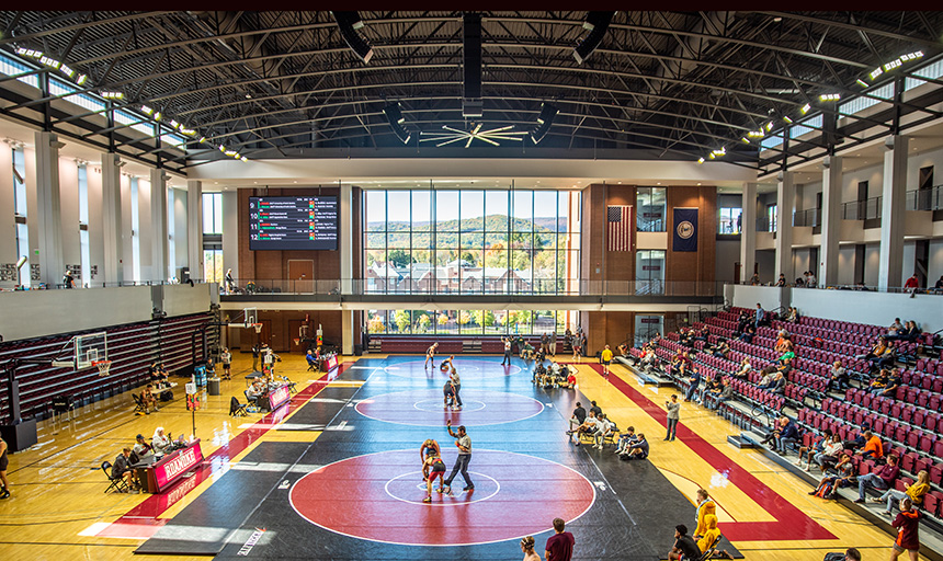 Wrestling meet in Cregger Center with mountains and building visible through window
