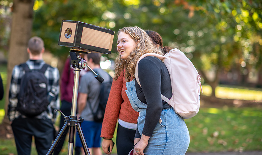 Student looks through camera obscura chamber