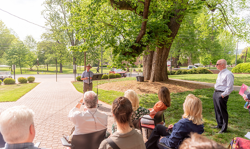 people gathered on campus next to the champion dutch elm tree