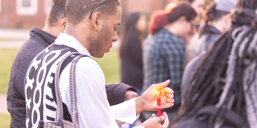 A student holds a lit candle during Sunday's vigil