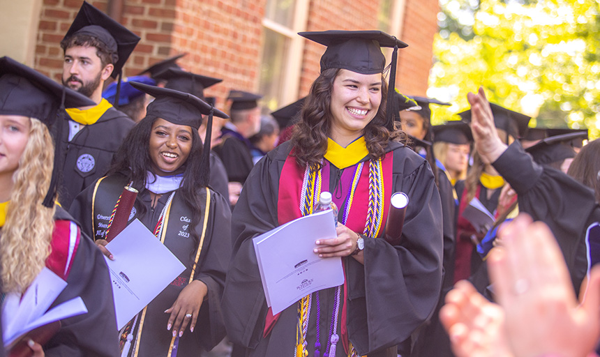 Class of 2023 graduates smile during commencement procession