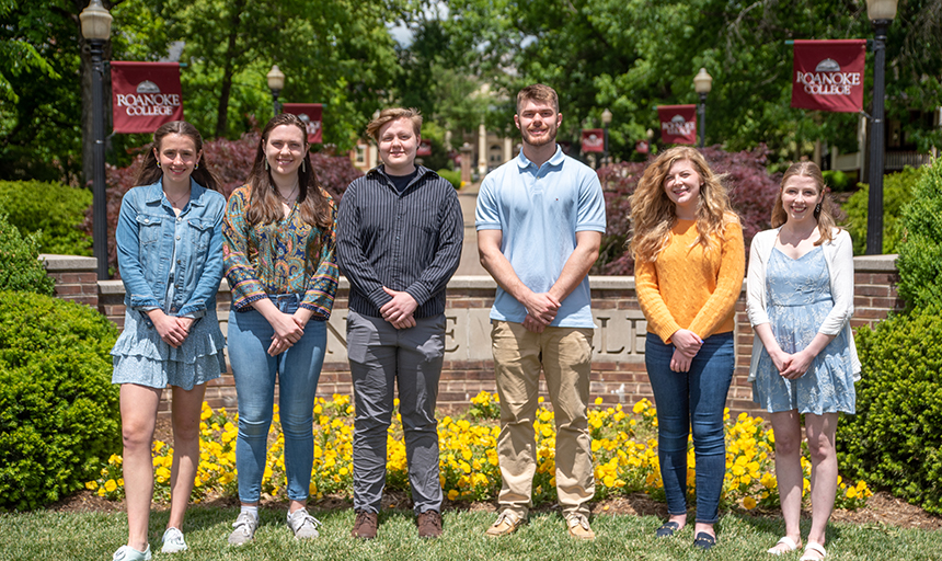 Six people standing in front of Roanoke College sign