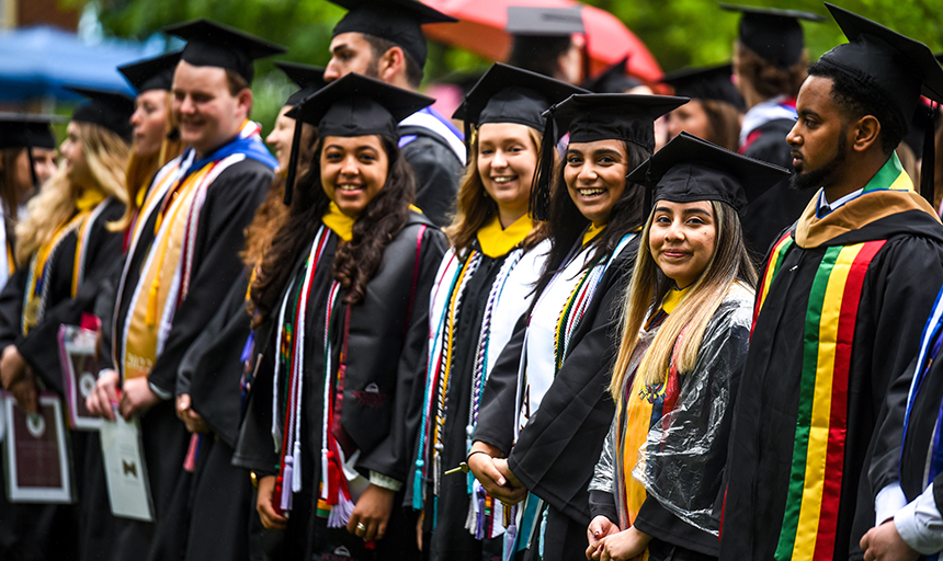 graduates in caps and gowns line up for commencement