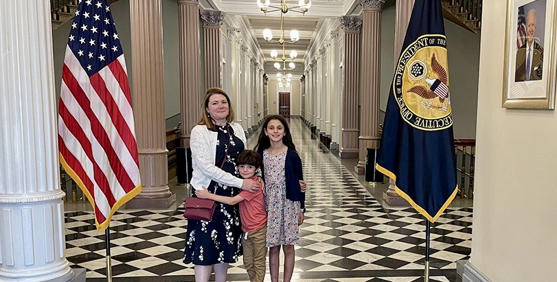 Karin Saoub and family members smile for a photo inside a building of the Executive Office of the President