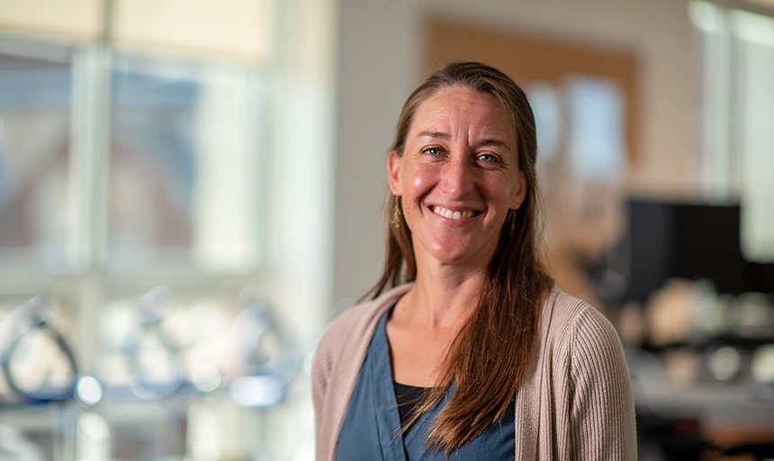 Liz Ackley smiles for a photo in an on-campus exercise room