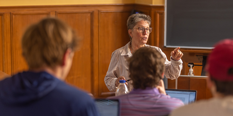 A professor gestures while talking to the class