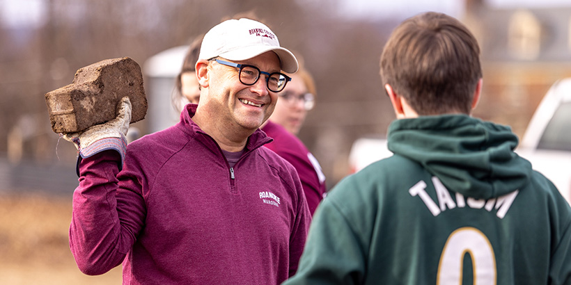 President Shushok talks to a student with a brick in his hand