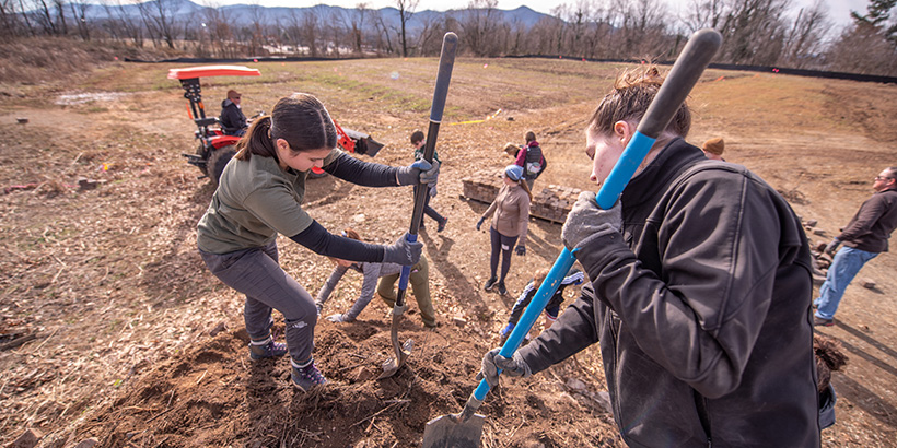 Students shovel mulch and soil