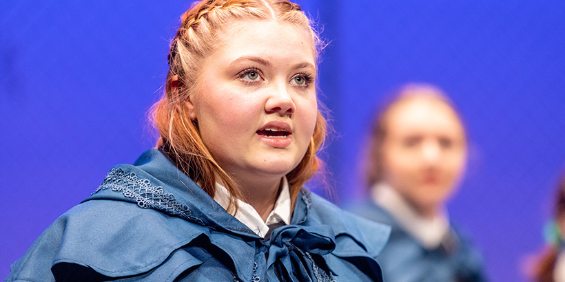 Close-up photo of an actor playing Macbeth speaking while clothed in a vivid cloak