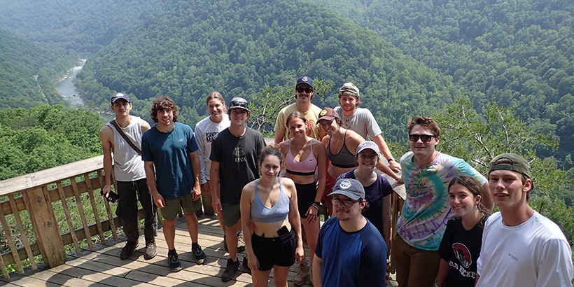 Students take a group photo at a manmade overlook built to offer an expansive view of the river and mountains below