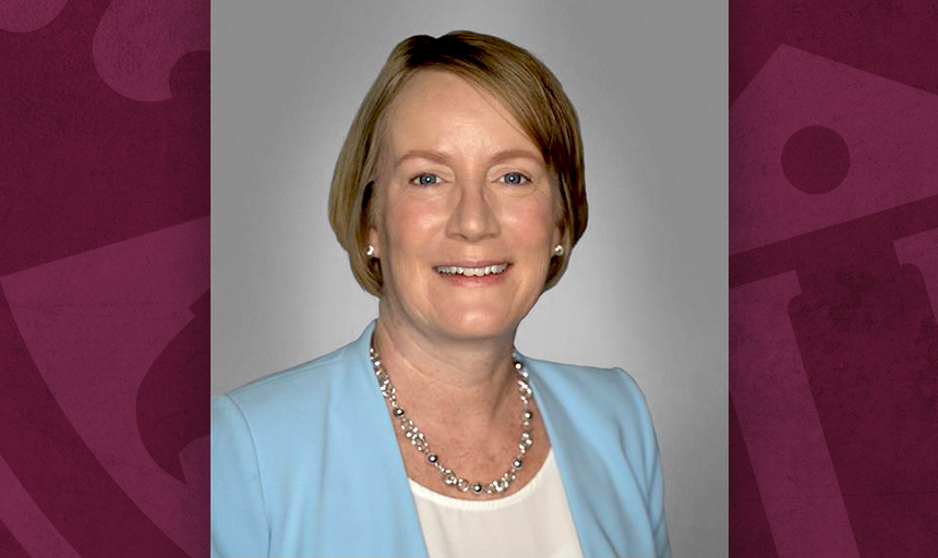 Head shot of woman in a light blue blazer with maroon borders on each side of the photo