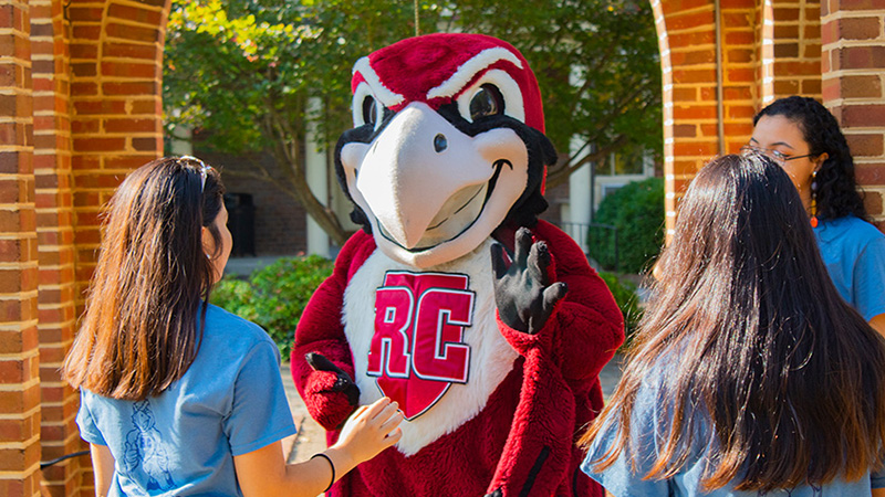 Rooney waves and greets students on the back quad