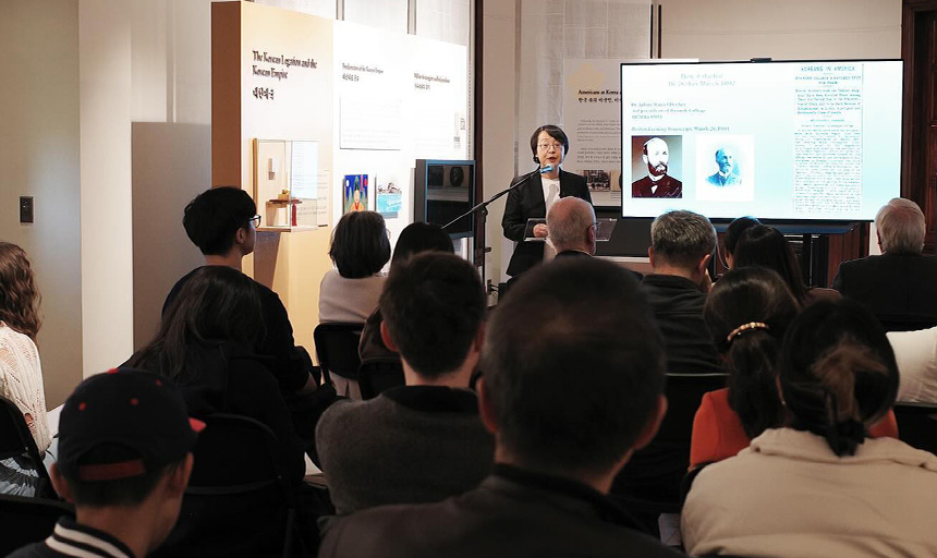 Stella Xu speaking to a crowded room at the Old Korean Legation Museum.