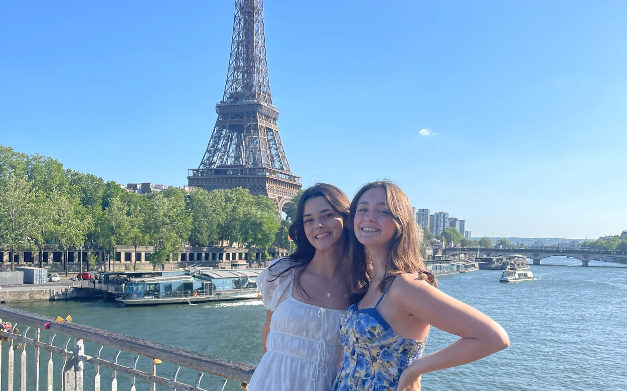 Zoe Pitney and a friend smiling in front of the Eiffel Tower