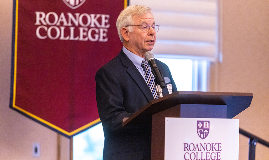 Tommy Barber at a podium with Roanoke College logo on podium and behind him