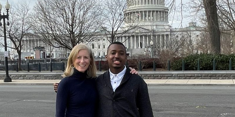 Isaiah Jacobs and a friend smile for a photo in front of the U.S. Capitol