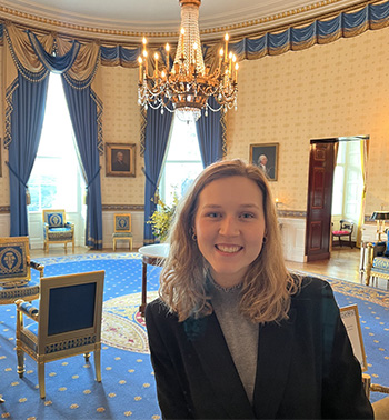 Katherine Vaughan smiles in a well-appointed state room of a D.C. building