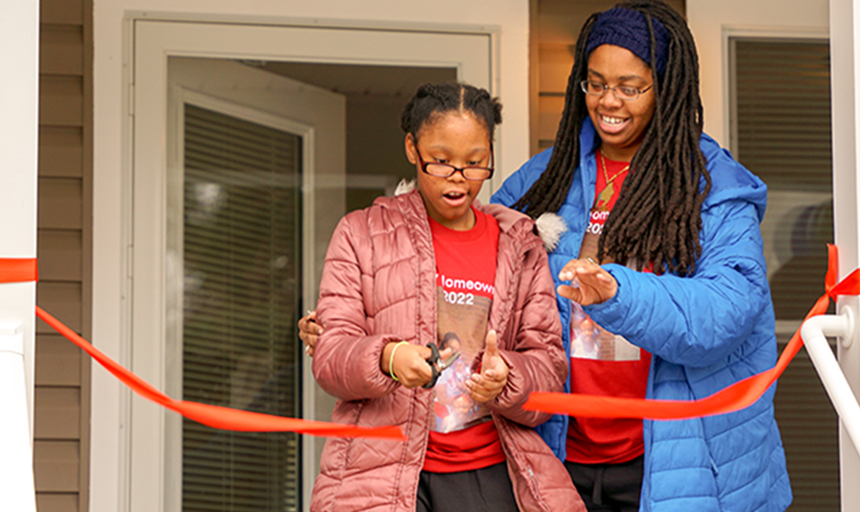 Homeowner and daughter cut ribbon to their new home