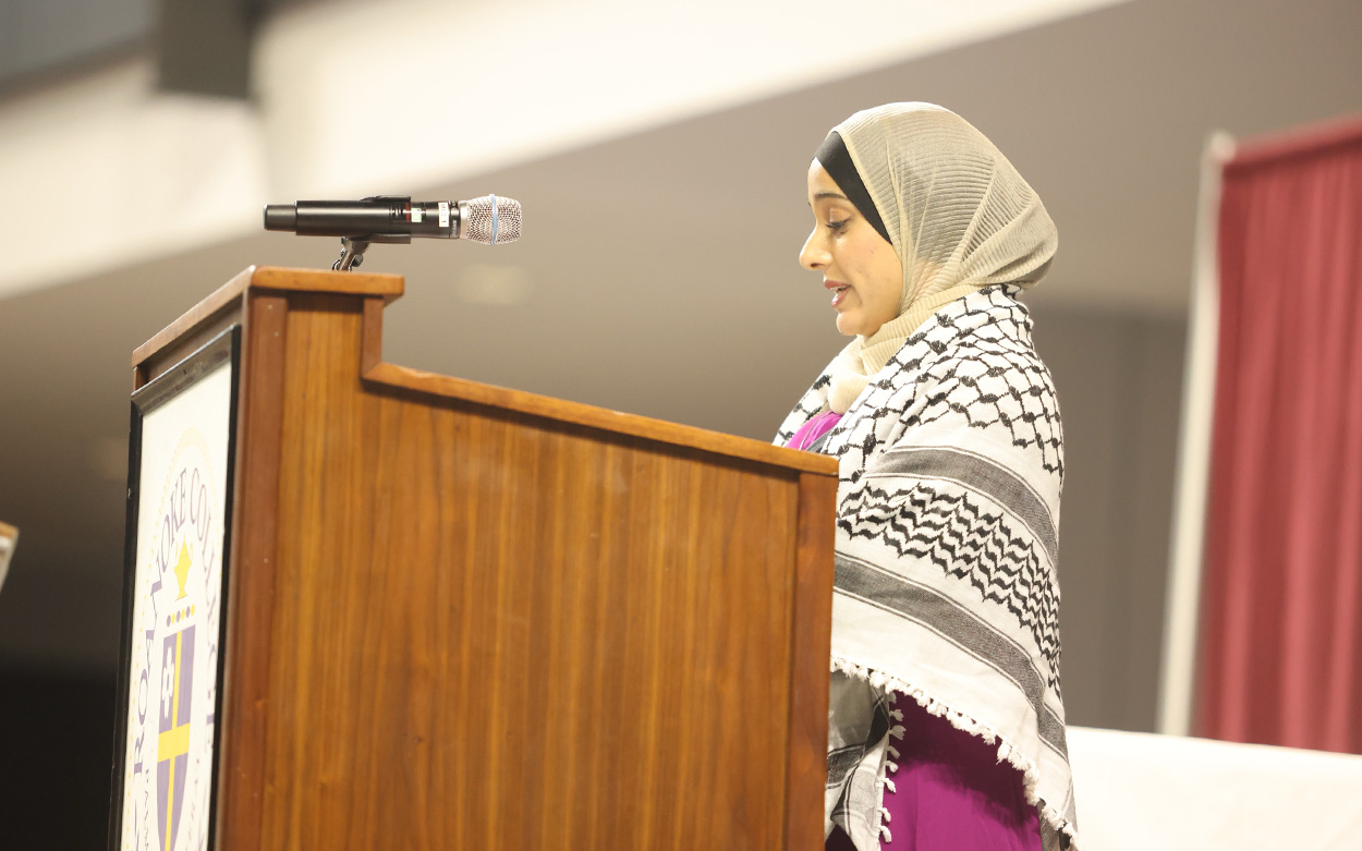 A student wearing a head scarf speaks during an interfaith blessing