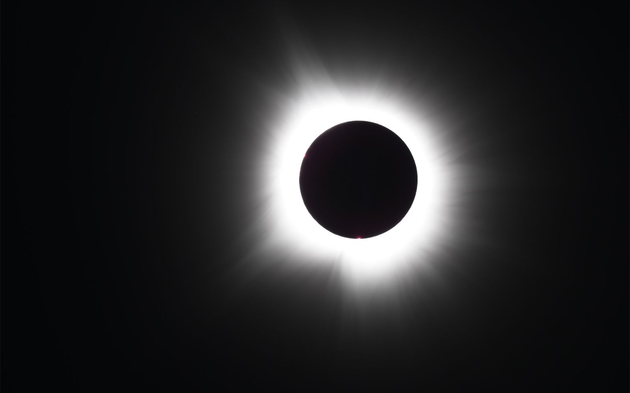 solar eclipse showing solar flares around the moon