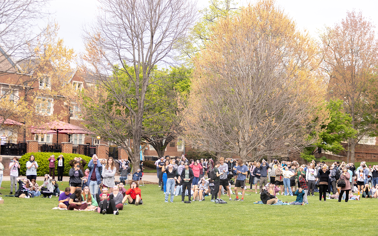 hundreds of people gather on Back Quad to watch the eclipse