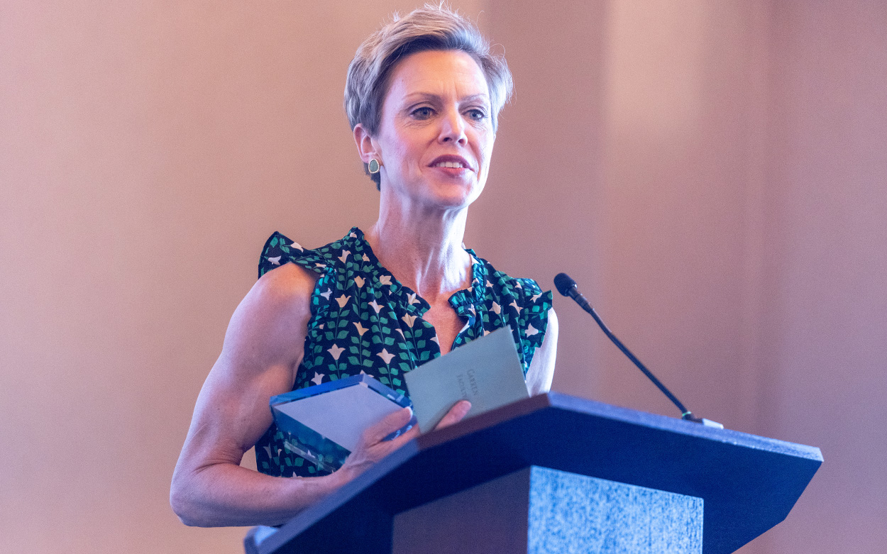 A woman thanks the audience while speaking from a podium