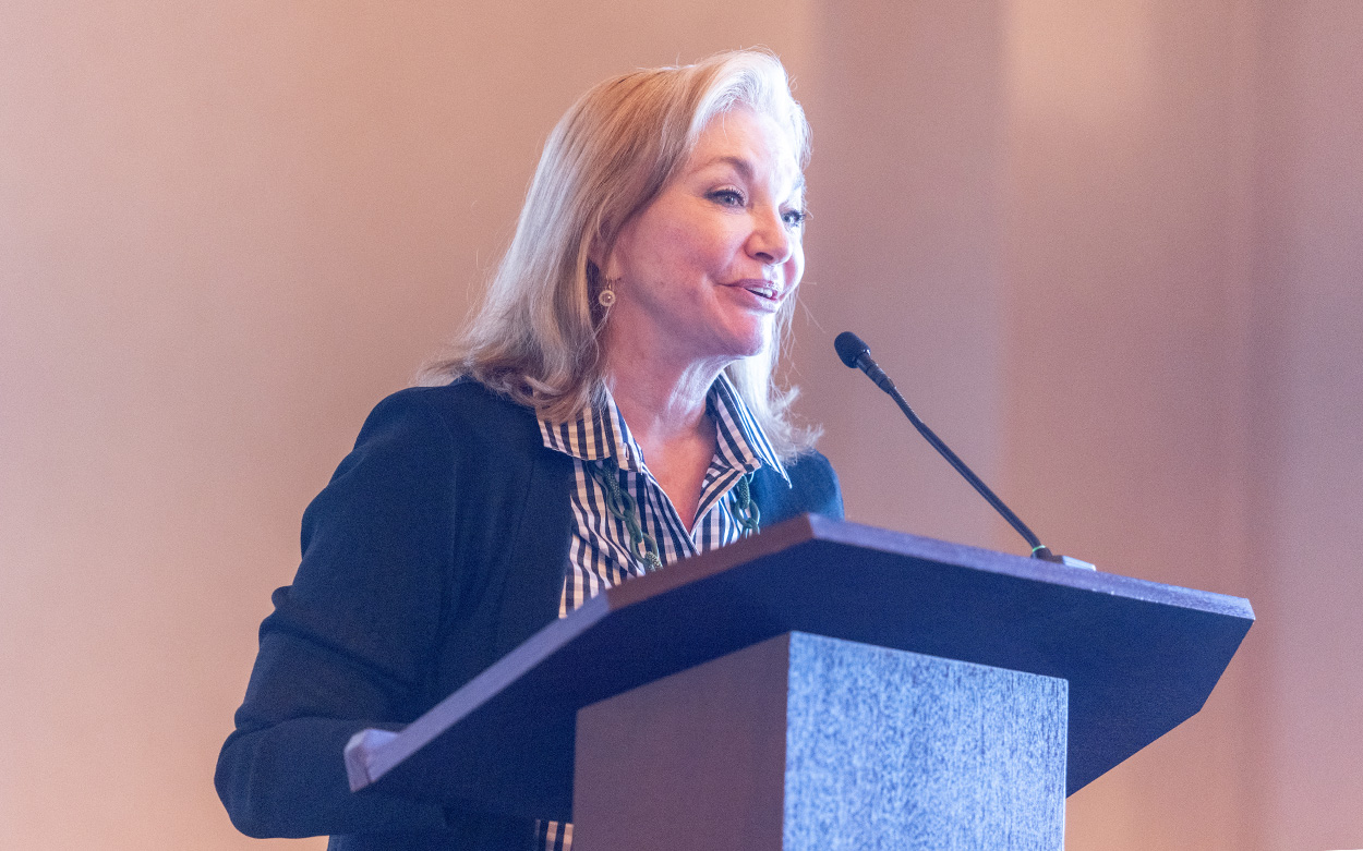 A woman addresses the gathering from a podium