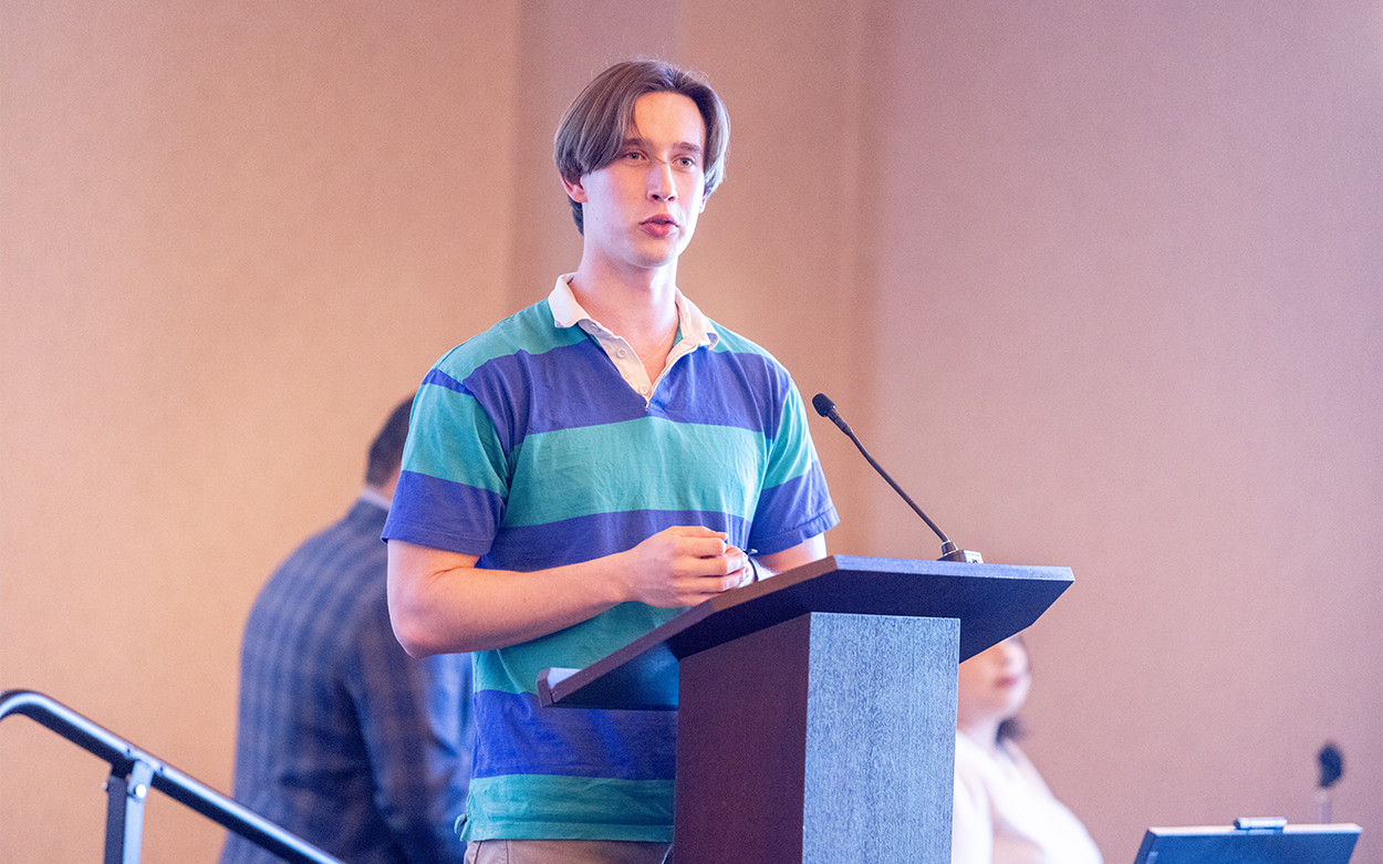 Young man addresses the audience from a podium